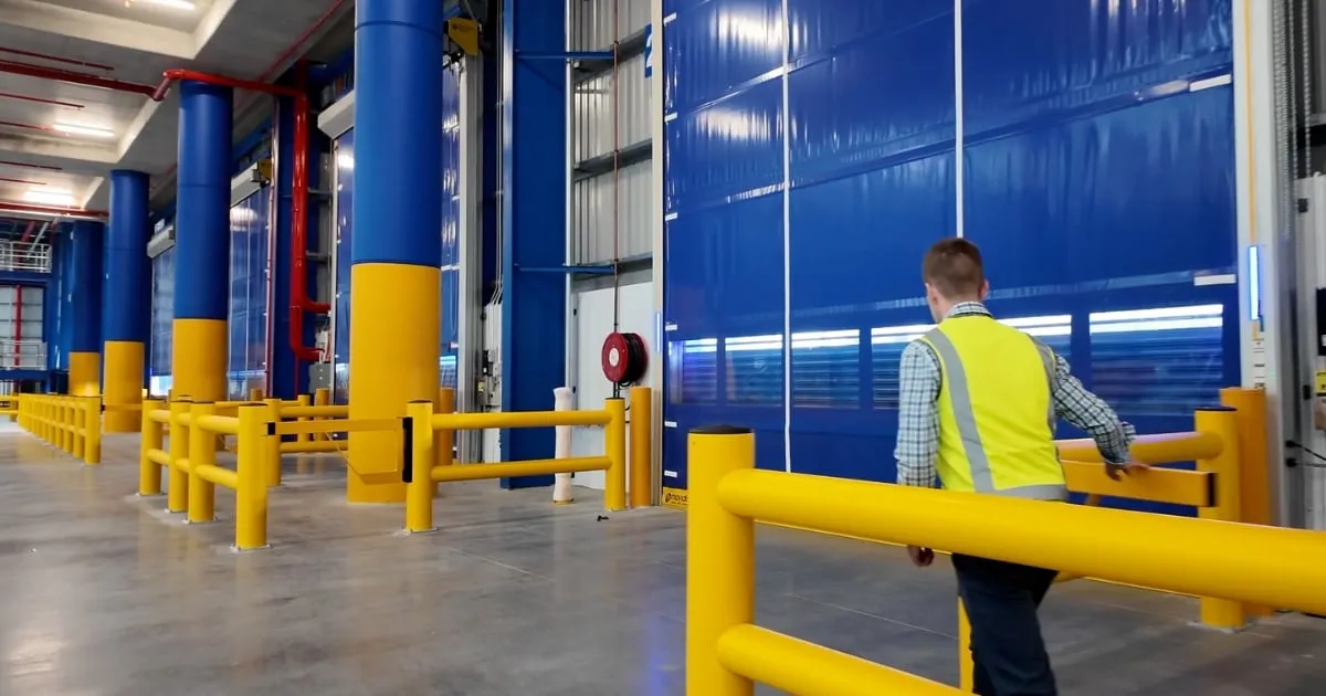 Worker in hi-vis vest inside industrial warehouse