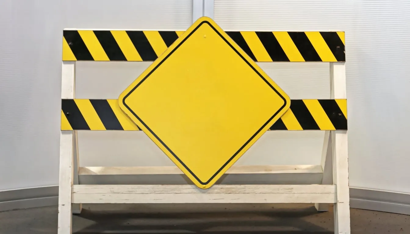 Blank yellow diamond road sign on hazard barrier