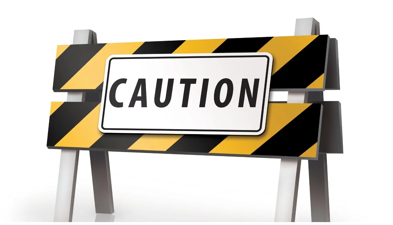 Caution sign on black and yellow barricade