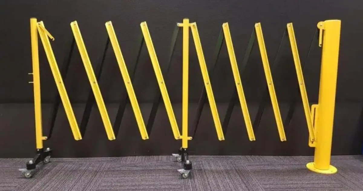 Yellow expandable safety barrier gate on wheels