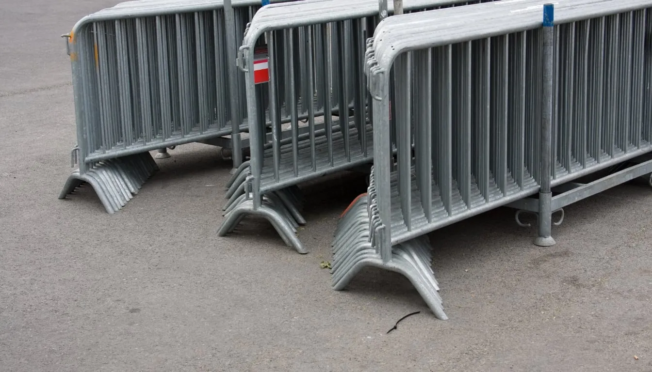 Stacked metal crowd control barriers on pavement