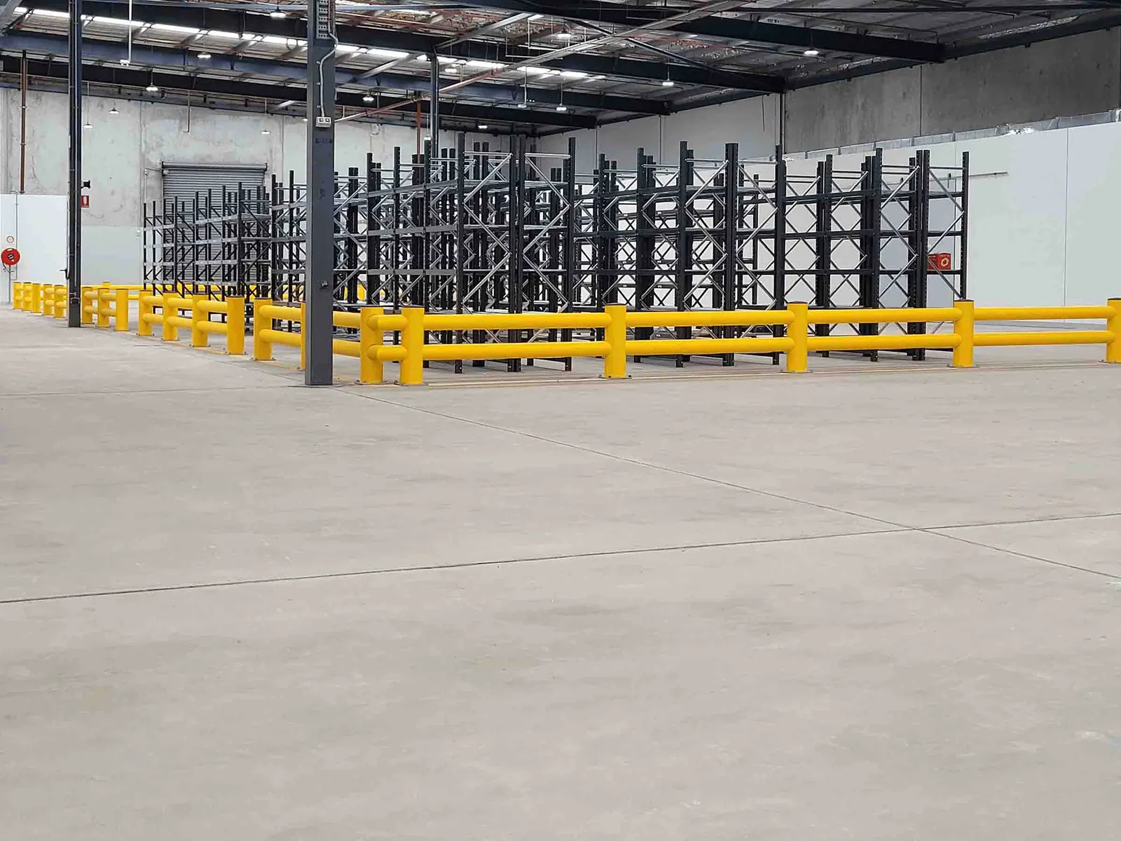 Yellow industrial guardrails installed on a concrete floor