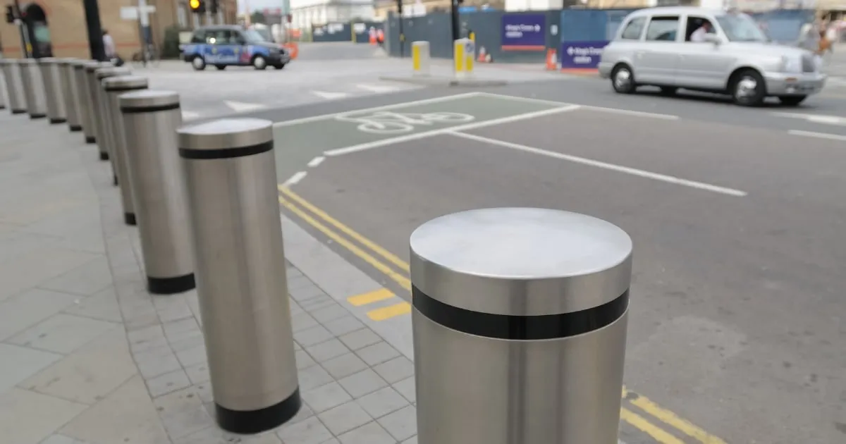 Metal bollards lining city street footpath