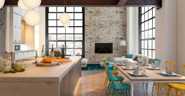 An airy, industrial-style loft featuring an open-plan kitchen and living area with a large brick accent wall