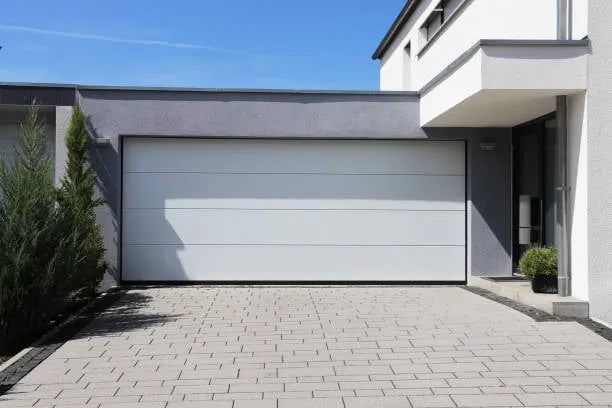 A sleek, white modern sectional garage door on a contemporary home