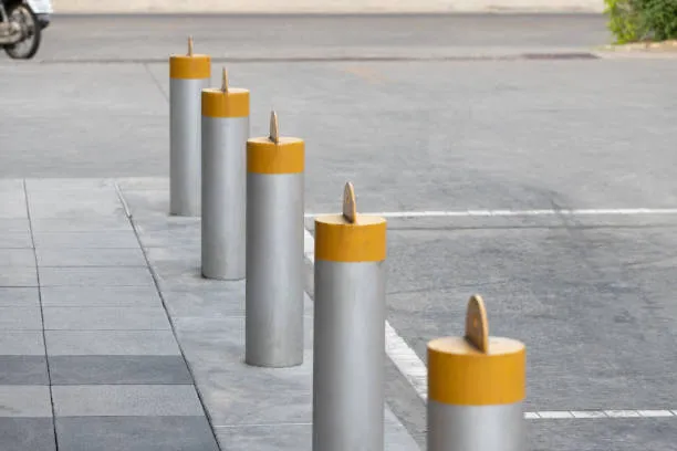 Metal bollards with yellow tops along footpath edge