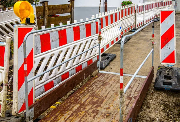 Red and white roadwork barriers with warning light