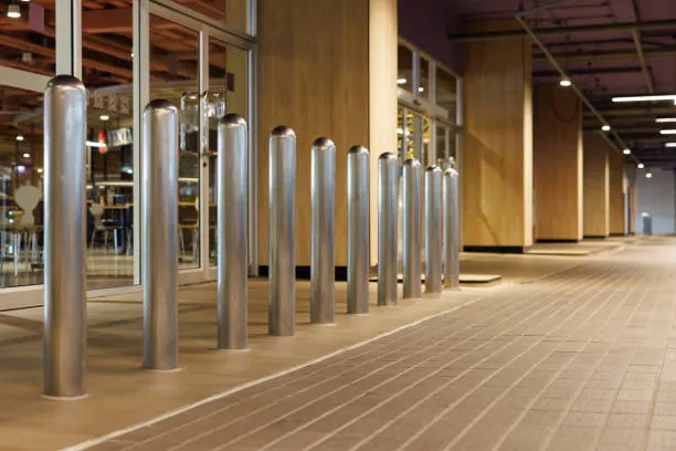 Metal bollards outside modern building entrance at night