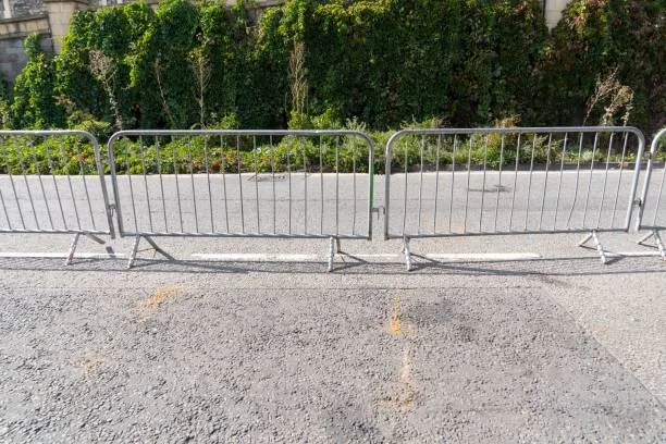 Metal crowd control barriers on asphalt road