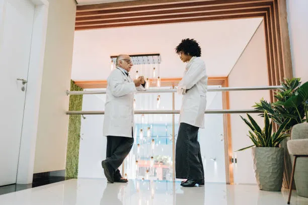 Two doctors talking in modern hospital corridor