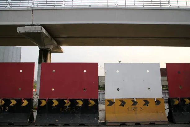 Red and white road barriers under overpass
