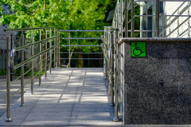 Wheelchair accessible ramp with handrails and disability sign