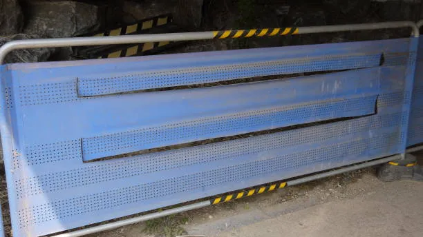 Metal roadside safety barrier with hazard stripes